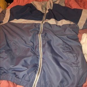 A light blue, dark blue and white wind breaker
